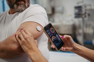 Monitoraggio della glicemia in un paziente con diabete tramite sensore e app mobile, soluzione digitale basata su intelligenza artificiale per supportare la terapia insulinica.